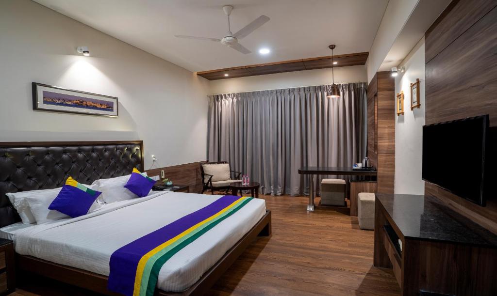 a hotel room with a bed and a television at Treebo Tryst Baramasi By Jai Club Prime in Jaipur