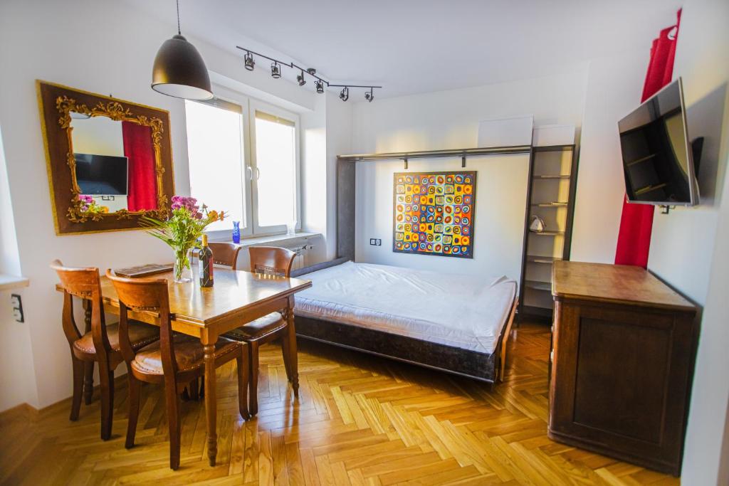 a bedroom with a bed and a table and a dining room at Charming Apt next to Lazienki Park and City Center in Warsaw