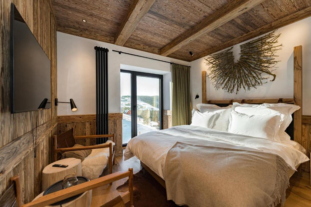 sypialnia z dużym łóżkiem i dużym oknem w obiekcie Nový pokoj Hotelu Emerich w mieście Pec pod Sněžkou