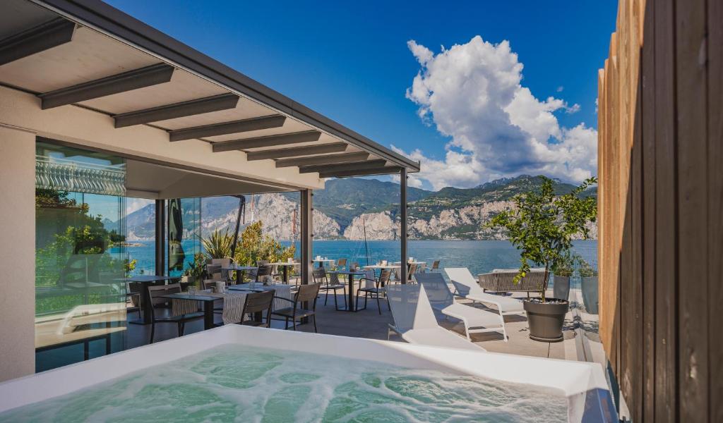 a hot tub on a patio with a view of the water at Gabbiano in Malcesine