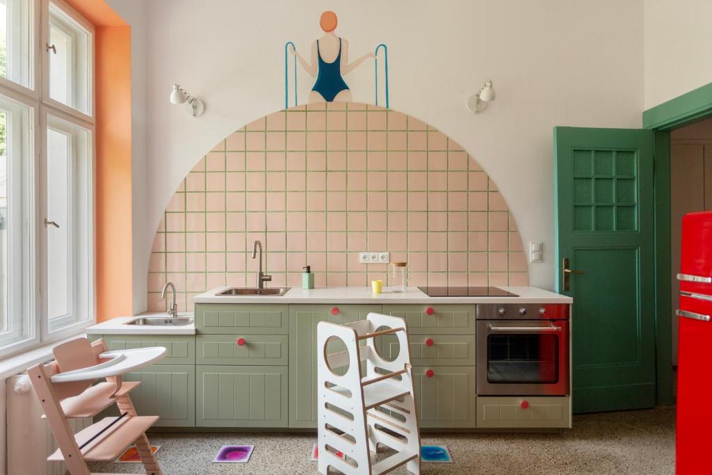 a kitchen with green cabinets and a ladder at Sopociaki in Sopot