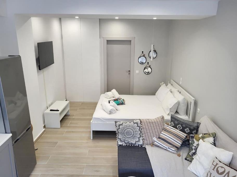 ein weißes Zimmer mit einem Bett und einem Sofa in der Unterkunft Little Fox Corfu 3 in Alepou