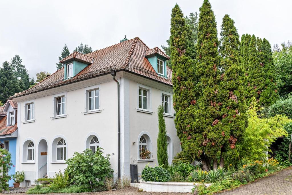 uma casa branca com árvores em frente em Appartement Waldhorn em Badenweiler