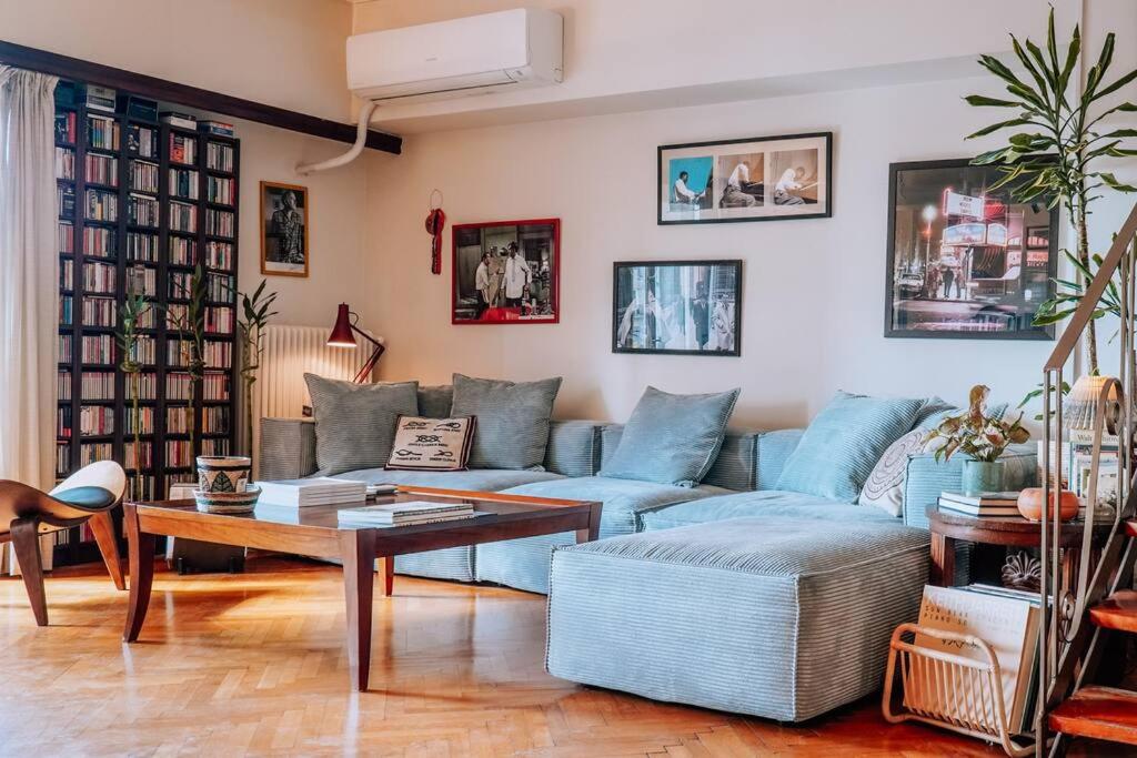 sala de estar con sofá azul y mesa en Chic 2BR Bright Penthouse with Open Wood Staircase, en Atenas