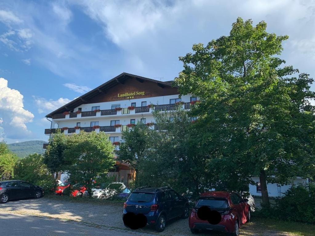 a hotel with two cars parked in front of it at Ferienwohnung "Zirbenduft" im Landhotel Seeg in Seeg