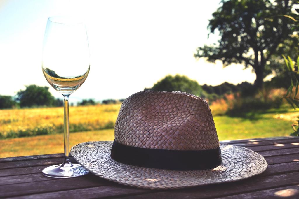 a hat and a glass of wine on a wooden table at Haus Jehle in Görwihl