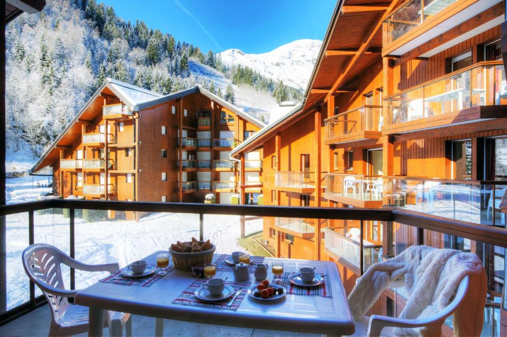 een tafel en stoelen op het balkon van een skigebied bij Résidence Néméa Le Nevez in Les Contamines-Montjoie