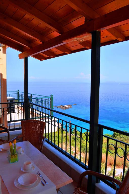 a view of the ocean from the balcony of a house at Mari-Christi Apartments in Poros