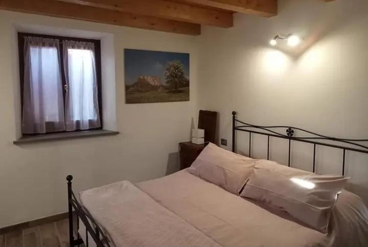 Schlafzimmer mit einem Bett und einem Fenster in der Unterkunft b&b La Divina Pietra 