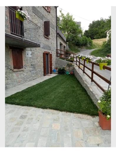 a yard with a fence next to a building at b&b La Divina Pietra in Carnola