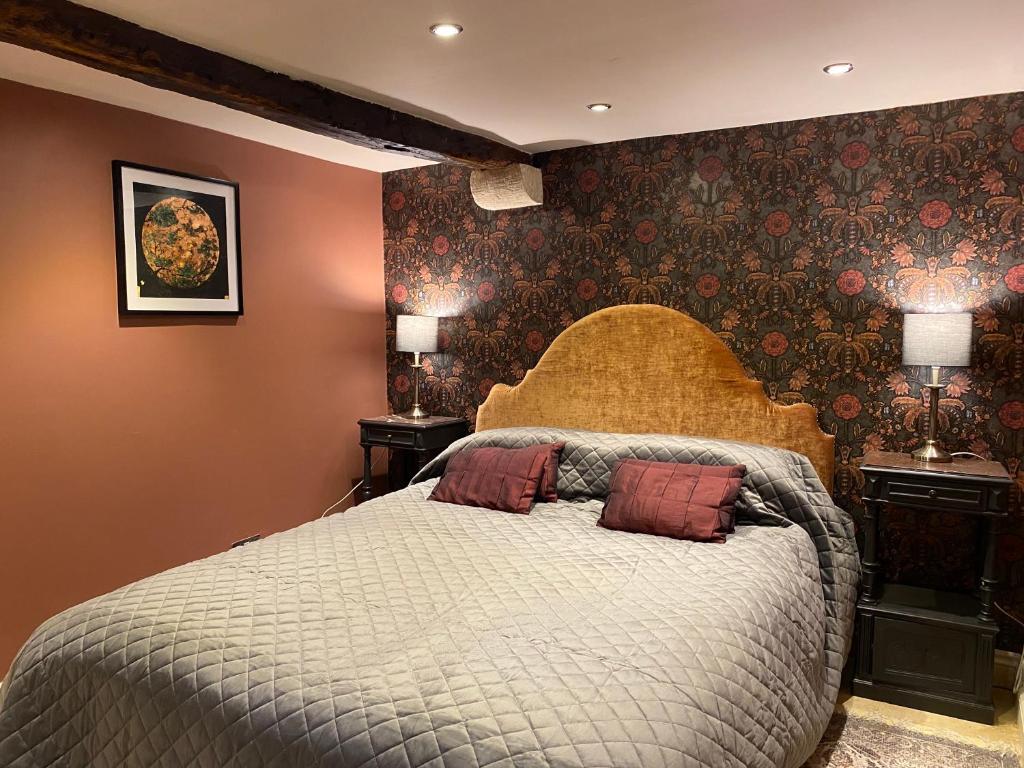 a bedroom with a bed with two pillows on it at Linden Retreat in Brimscombe