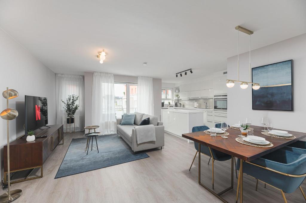 een woonkamer met een eettafel en een keuken bij DELUXE APARTMENT 2 Schlafzimmer - kostenlos Parken - Messe Flughafen - Balkon - Netflix in Leinfelden-Echterdingen