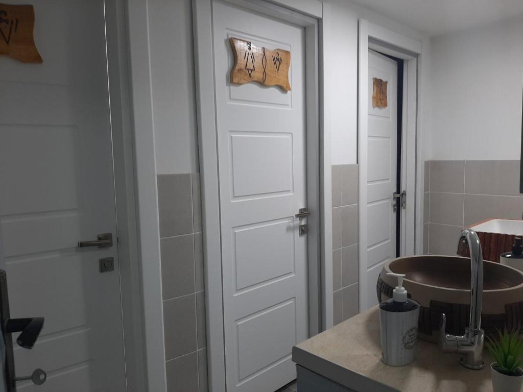 a bathroom with a sink and a white door at Beli Kamen etno selo in Prokuplje