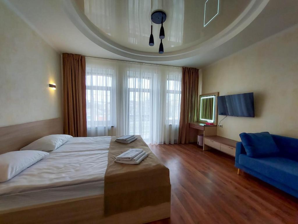 1 dormitorio con 1 cama grande y 1 sofá azul en Graff Hotel, en Dnipro