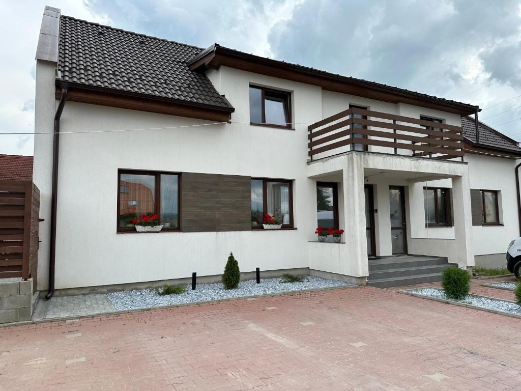 uma casa branca com janelas pretas e uma entrada em Bokorlak 3 em Odorheiu Secuiesc