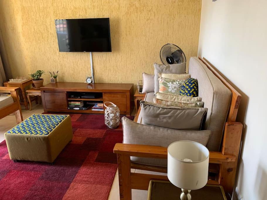 ナイロビにあるLovely Apartment in Westlandsのリビングルーム(ソファ、テレビ付)