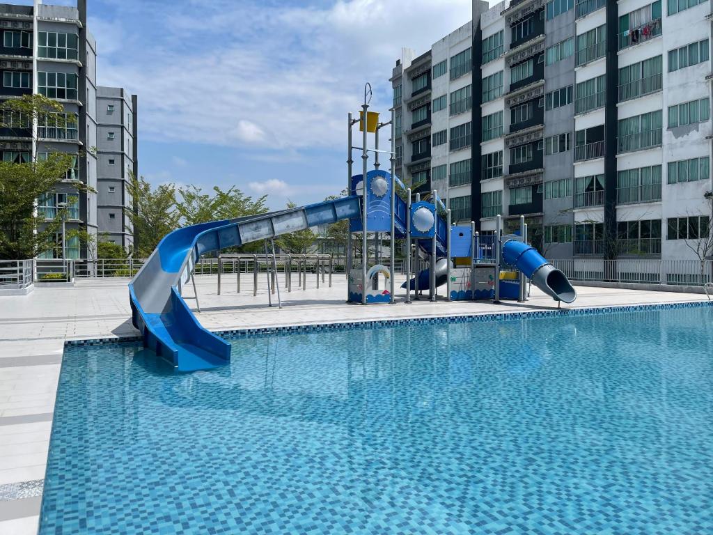 a water slide in a pool in a city at Modern Stylish Apartment near Kuching Airport in Kuching