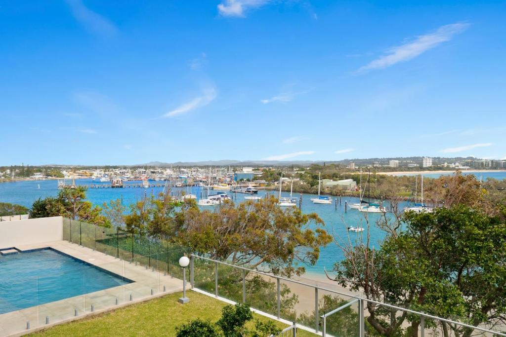 a view of a marina with boats in the water at Oceanfront apartment on top of point Cartwright in Buddina
