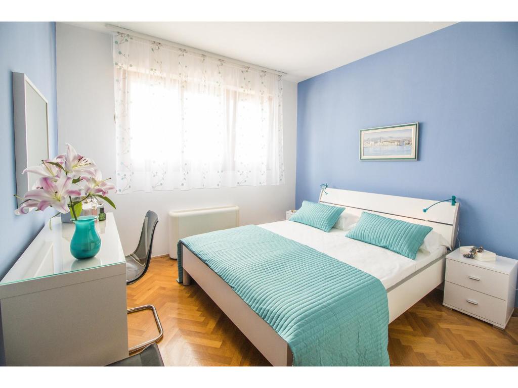 a bedroom with a bed with a blue wall at Apartment Seagull in Split
