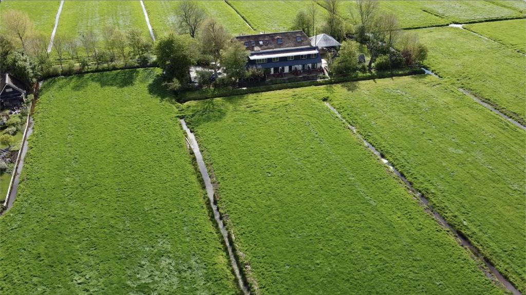 an aerial view of a large green field with a house at The Meetinn in Waverveen