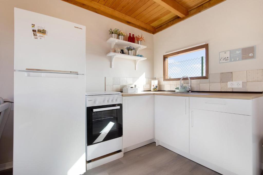 a kitchen with white cabinets and a white refrigerator at Casa Barranco de la Sal in Puerto del Rosario