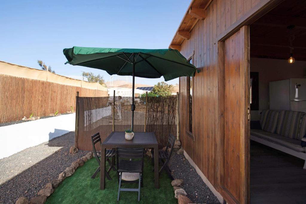 a table with a green umbrella on a patio at Casa Barranco de la Sal in Puerto del Rosario