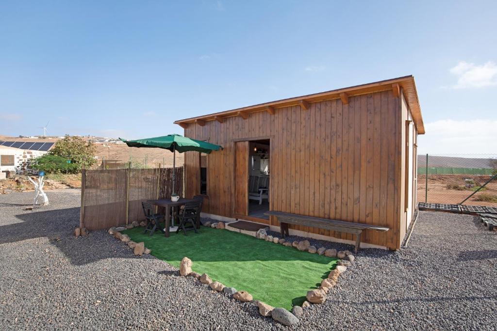 a small shed with a table and an umbrella at Casa Barranco de la Sal in Puerto del Rosario