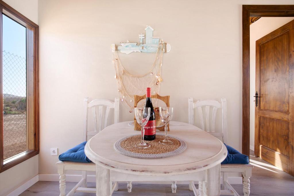 a table with two glasses and a bottle of wine at Casa Barranco de la Sal in Puerto del Rosario