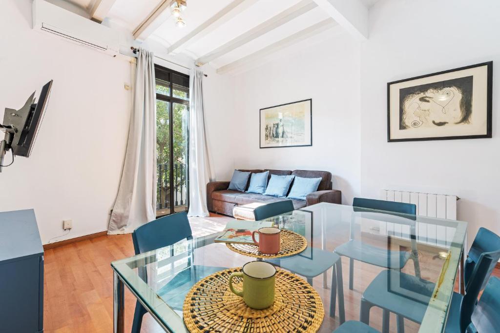 een woonkamer met een glazen tafel en stoelen bij Charming Apartment In Clot in Barcelona