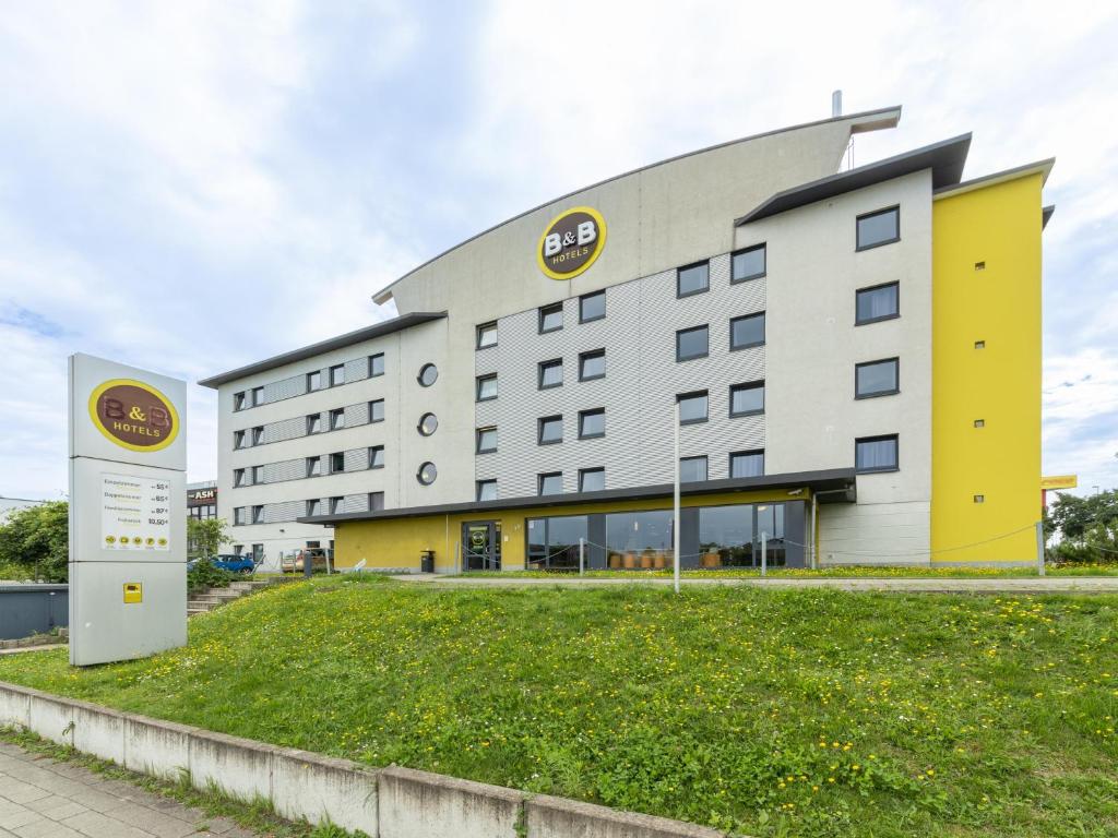 ein Hotelgebäude mit einem Schild davor in der Unterkunft B&B Hotel Oberhausen am Centro in Oberhausen