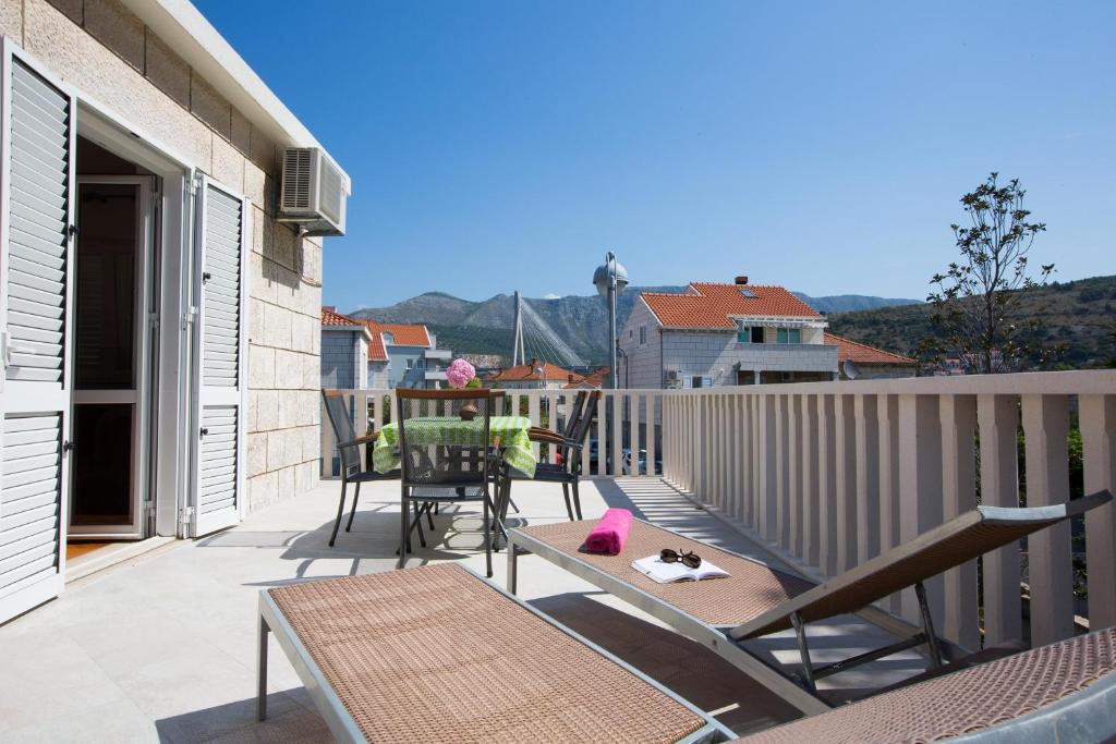 een patio met een tafel en stoelen op een balkon bij Aida Apartments and Rooms for couples and families FREE PARKING in Dubrovnik