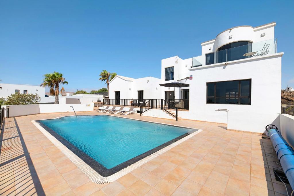 a villa with a swimming pool in front of a house at Casa Insitu in El Mojón