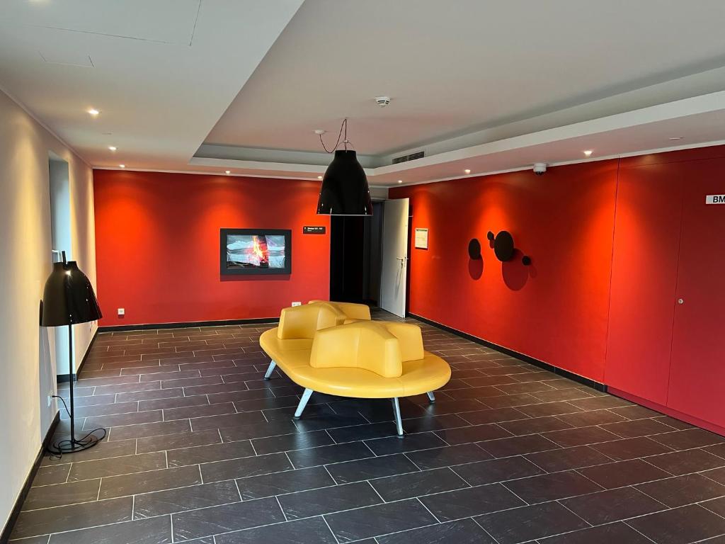 a waiting room with a yellow table and chairs at Serways Hotel Lüneburger Heide West in Behringen