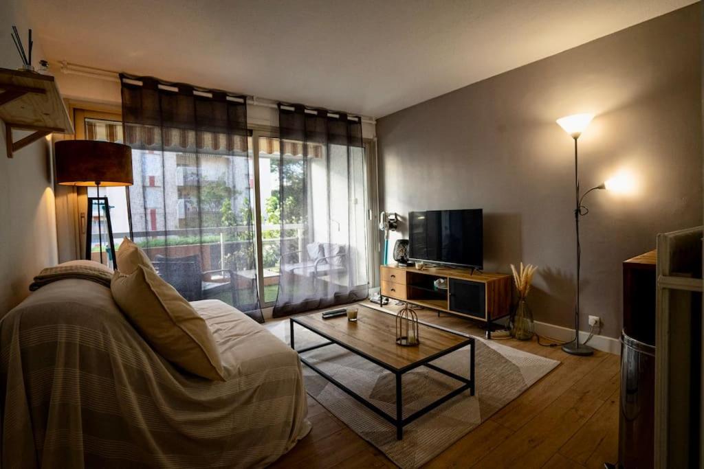 un salon avec un canapé, une table et une télévision dans l'établissement Appartement à Santa Lucia Vue Mer, à Saint-Raphaël