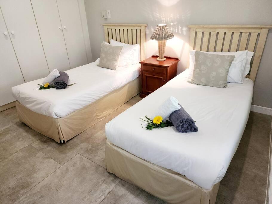 Dos camas en una habitación con flores. en Villa A23 - Selborne Golf Estate en Pennington