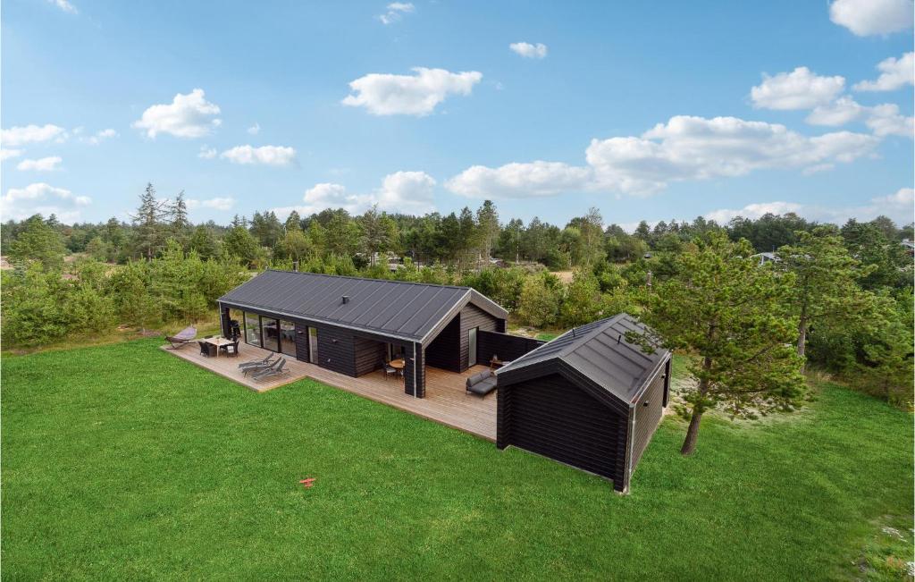 una vista aérea de una cabaña negra en un campo de hierba en 4 Bedroom Stunning Home In Strandby en Strandby