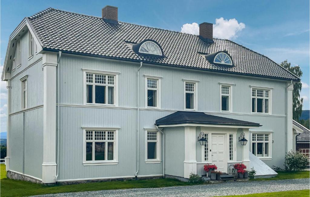 a white house with a gambrel roof at Amazing Home In Koppang With Wifi And 8 Bedrooms in Koppang