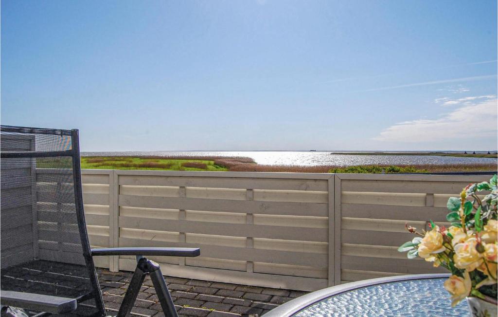 a patio with a chair and a table and the ocean at 2 Bedroom Gorgeous Home In Hvide Sande in Havrvig