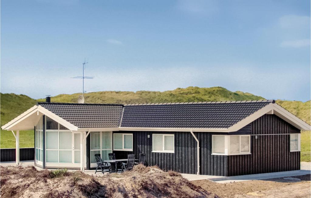 a black and white house on a beach at Gorgeous Home In Hvide Sande With Sauna in Hvide Sande