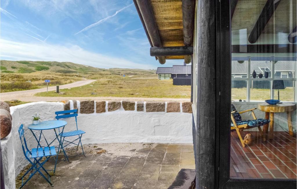 een uitzicht vanaf de veranda van een huis met stoelen en een tafel bij 4 Bedroom Beach Front Home In Hvide Sande in Bjerregård