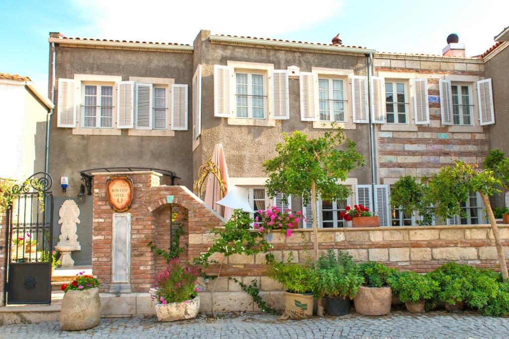 a building with potted plants in front of it at Alacati Kostem Hotel - Special Category in Alaçatı