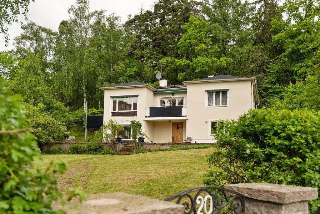 a white house in the middle of a yard at Room in a spacious villa in Stocksund