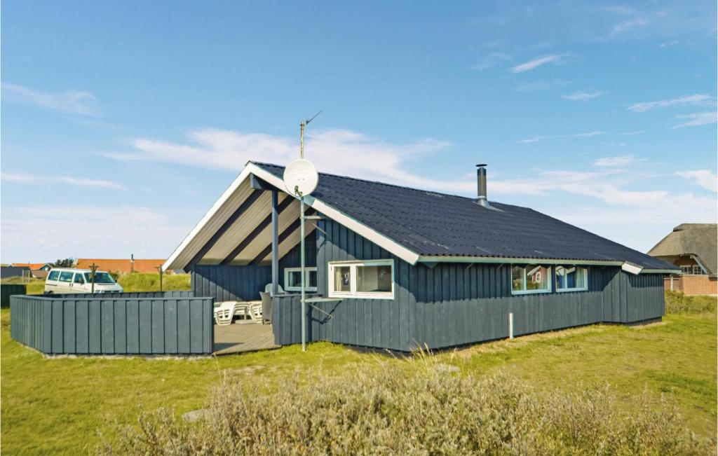 Havrvig的住宿－Stunning Home In Hvide Sande With Kitchen，一块地上有黑色屋顶的蓝色房子