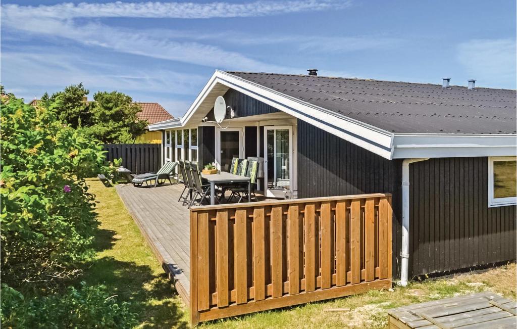 a house with a wooden deck in the yard at Pet Friendly Home In Hvide Sande With Kitchen in Havrvig