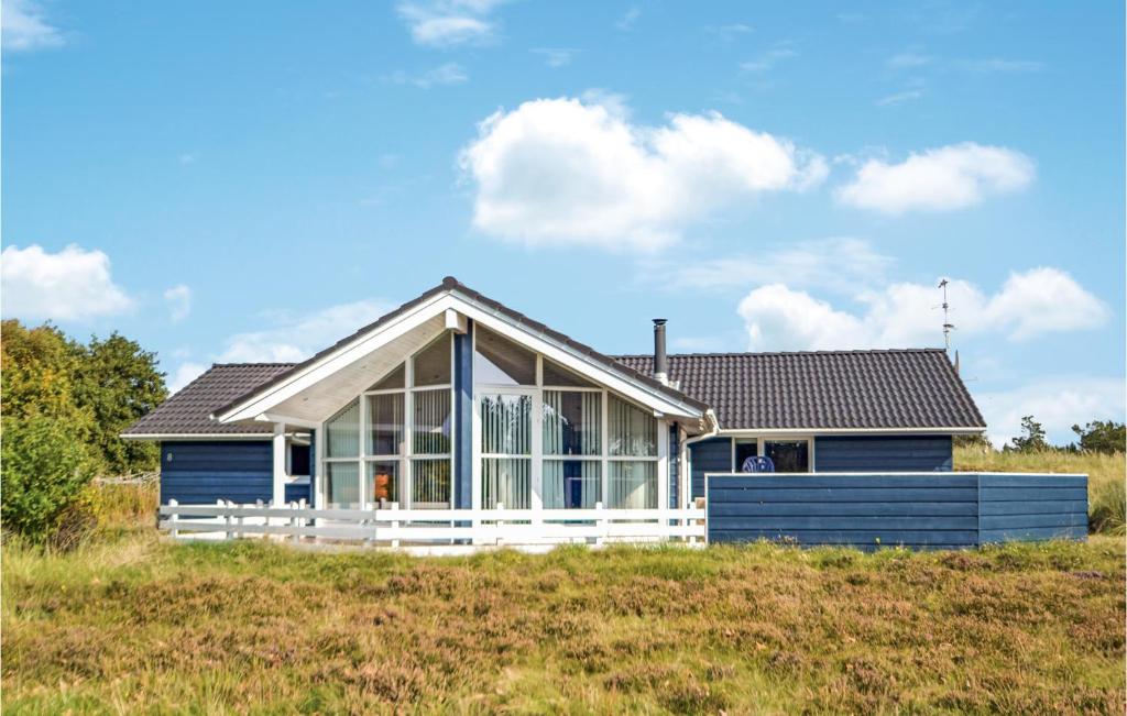 een huis met een blauw-wit huis bij 4 Bedroom Amazing Home In Hvide Sande in Bjerregård