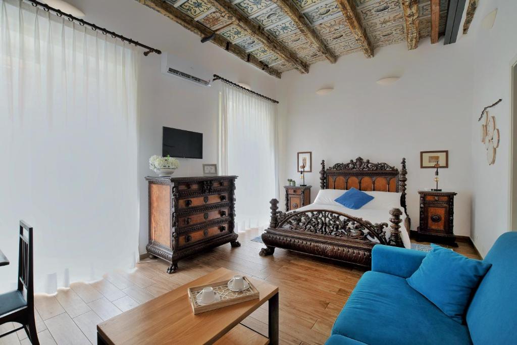 iFlat Palazzo Ragusi في باليرمو: غرفة نوم بسرير واريكة وطاولة