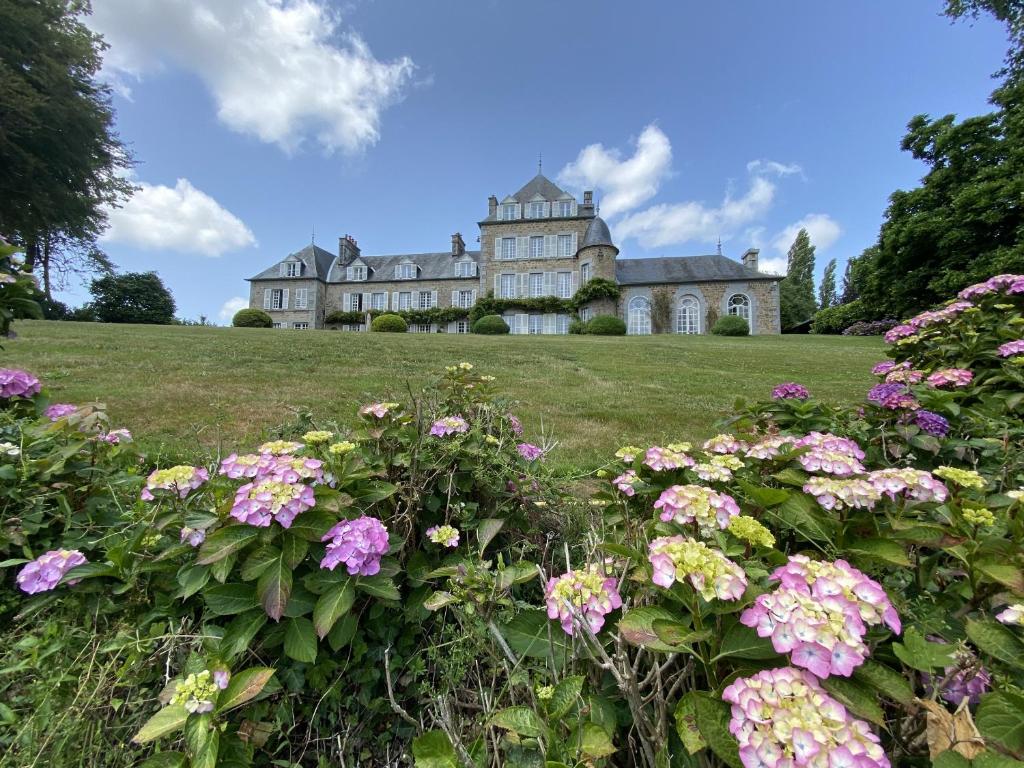 a large house on a hill with flowers at Chateau La Rametiere in Plomb