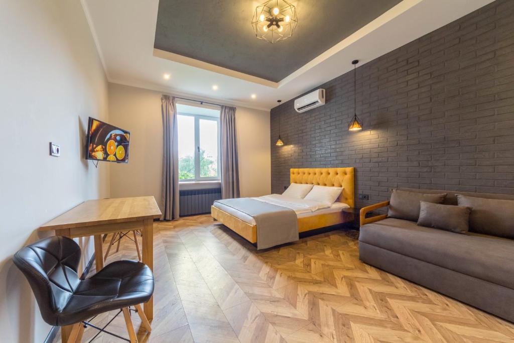 a bedroom with a bed and a couch at Idea Design Apart-Hotel Prorizna in Kyiv