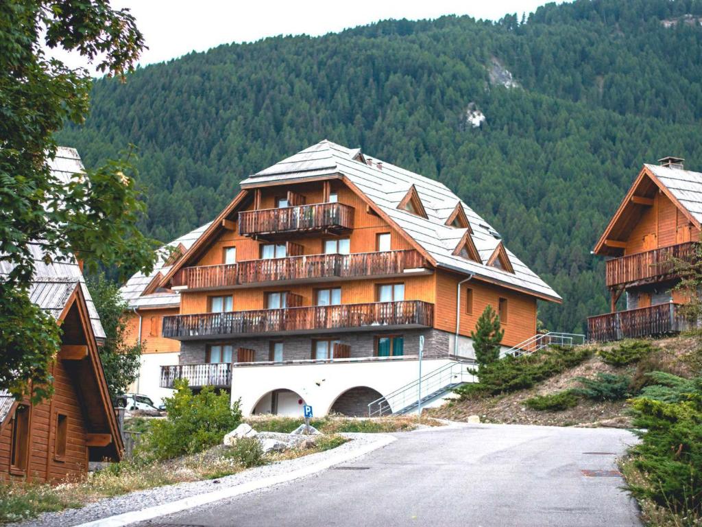a large building with balconies on the side of a mountain at Appartement Uvernet-Fours, 2 pièces, 6 personnes - FR-1-504-102 in Uvernet
