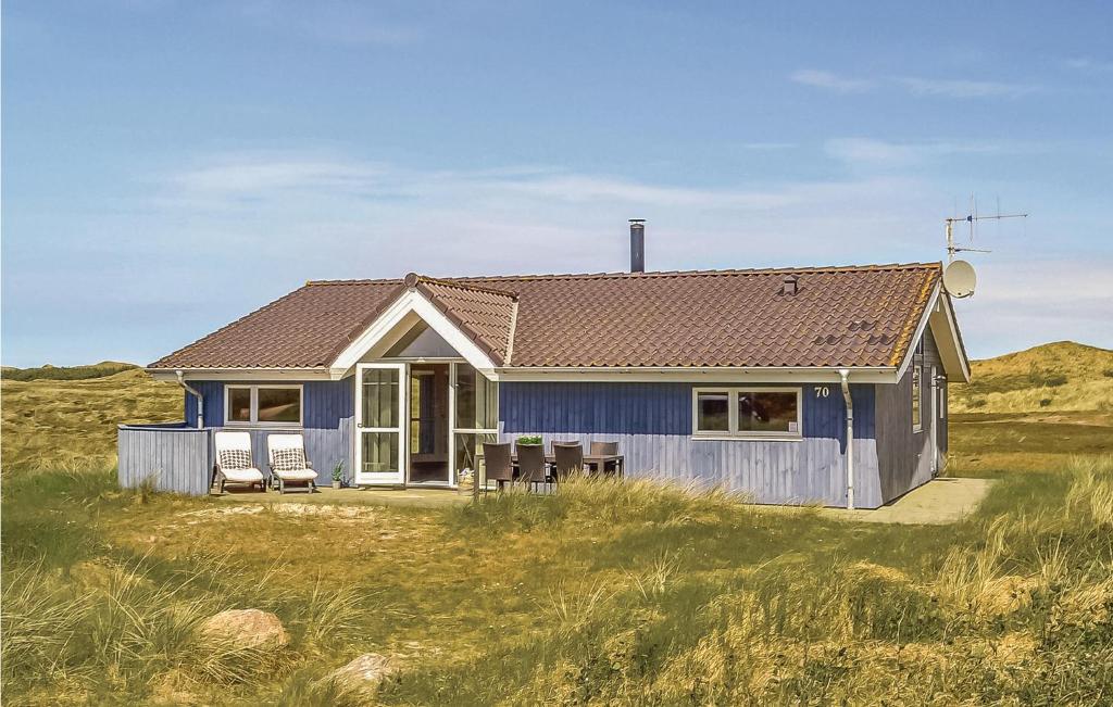 a blue house in the middle of a field at Gorgeous Home In Hvide Sande With Sauna in Havrvig